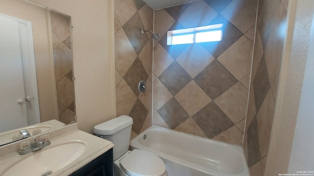 full bathroom with tiled shower / bath, vanity, and toilet