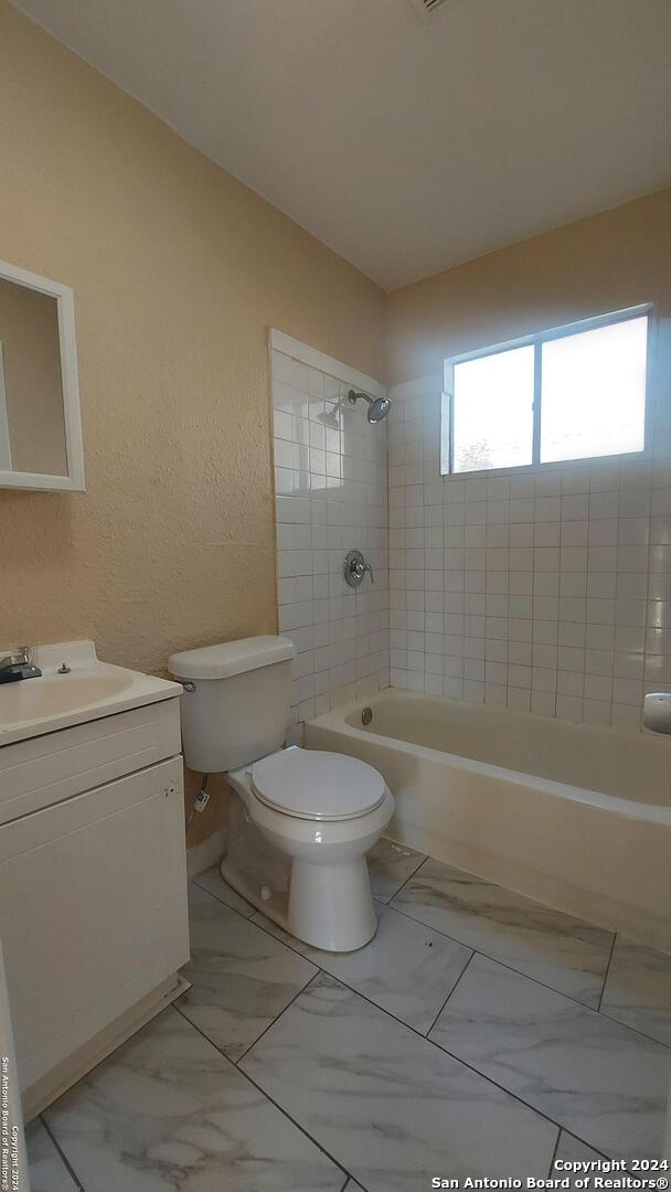 full bathroom featuring vanity, toilet, and tiled shower / bath