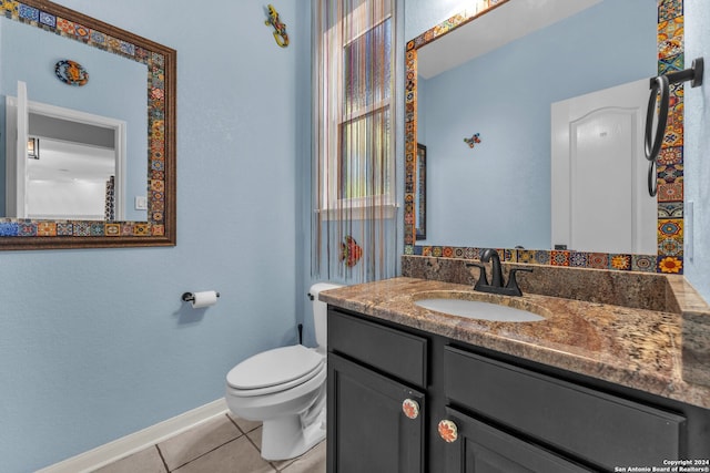 bathroom with tile patterned flooring, vanity, and toilet