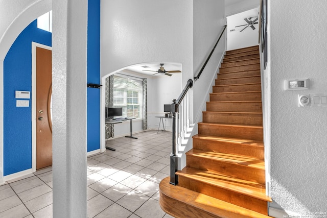 staircase featuring tile patterned floors and ceiling fan