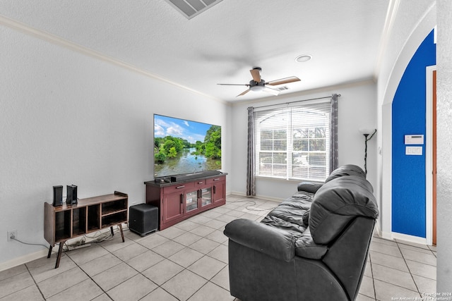 tiled living room featuring ceiling fan, a textured ceiling, and ornamental molding