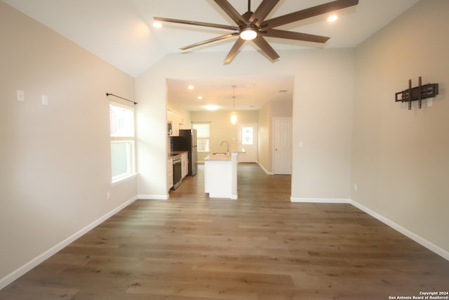 unfurnished living room with dark hardwood / wood-style floors, ceiling fan, lofted ceiling, and sink