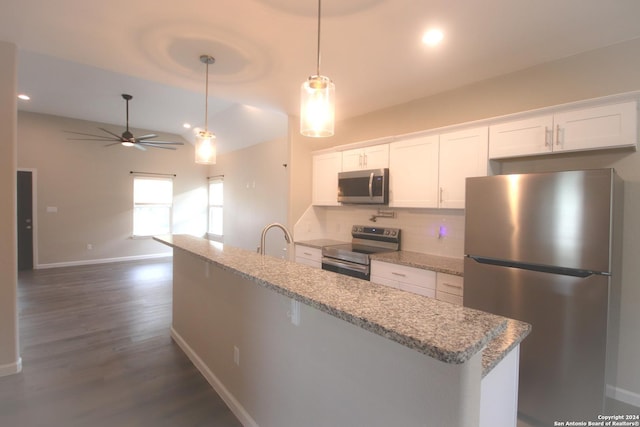 kitchen featuring white cabinetry, pendant lighting, light stone counters, and appliances with stainless steel finishes