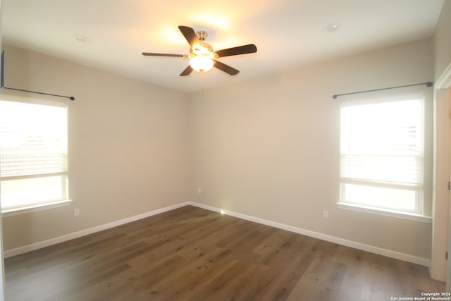 empty room with ceiling fan and dark wood-type flooring