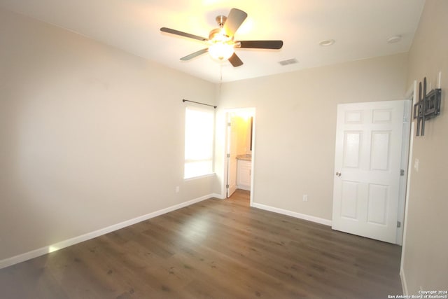 unfurnished bedroom with dark hardwood / wood-style flooring, ensuite bath, and ceiling fan