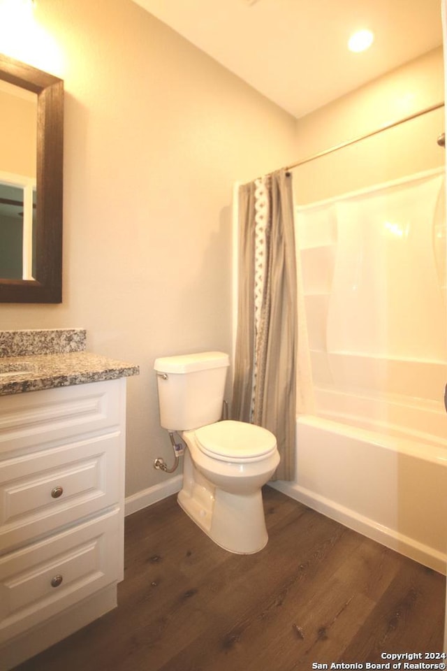 full bathroom featuring hardwood / wood-style floors, vanity, toilet, and shower / bath combo with shower curtain