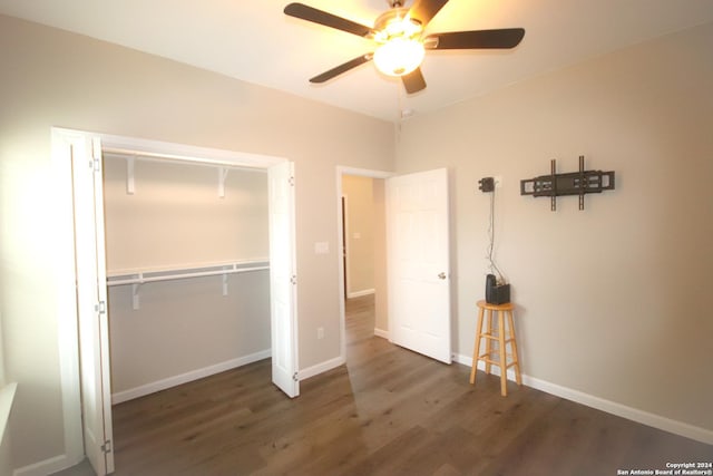 unfurnished bedroom featuring ceiling fan, dark wood-type flooring, and a closet