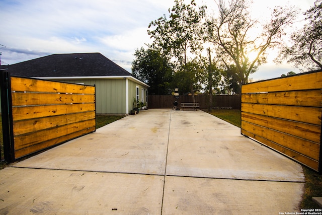 property exterior at dusk featuring a patio area