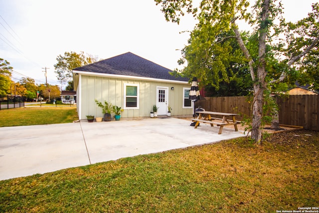 rear view of property with a yard and a patio