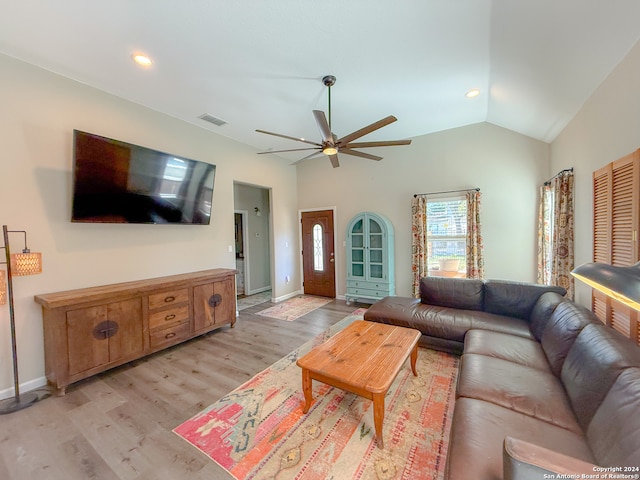 living room featuring ceiling fan, lofted ceiling, and light hardwood / wood-style flooring