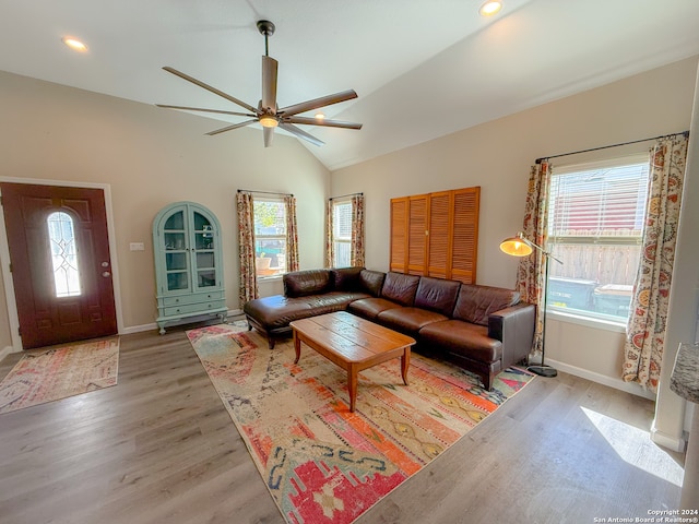 living room with light hardwood / wood-style floors, a wealth of natural light, lofted ceiling, and ceiling fan