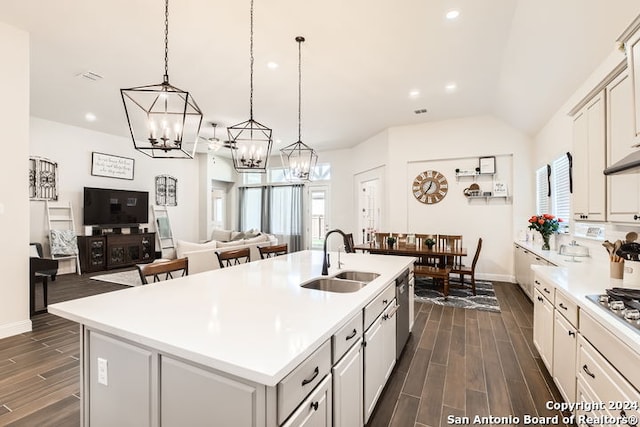 kitchen featuring pendant lighting, dark hardwood / wood-style flooring, sink, and a kitchen island with sink