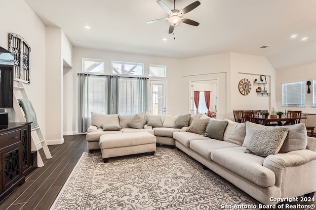 living room with ceiling fan, lofted ceiling, and dark wood-type flooring