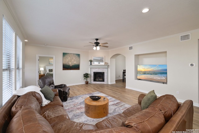 living room featuring light hardwood / wood-style flooring, ceiling fan, and crown molding