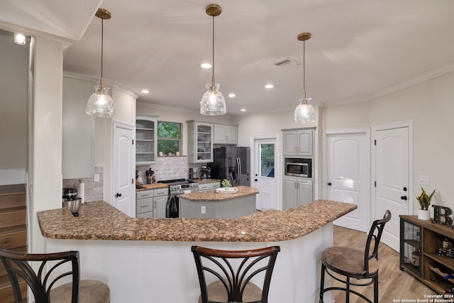 kitchen featuring light hardwood / wood-style flooring, decorative backsplash, ornamental molding, appliances with stainless steel finishes, and kitchen peninsula