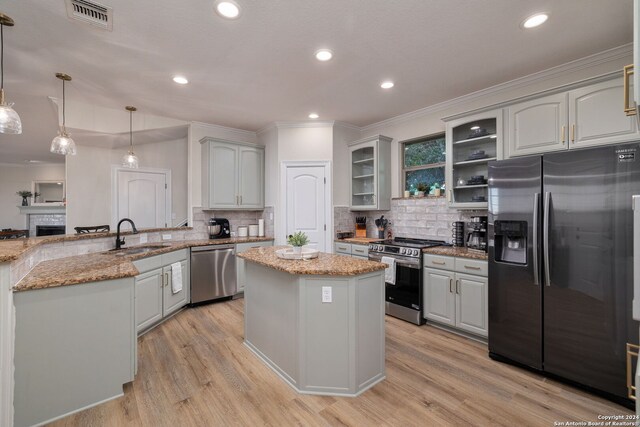 kitchen featuring white cabinetry, light stone countertops, stainless steel appliances, and hanging light fixtures