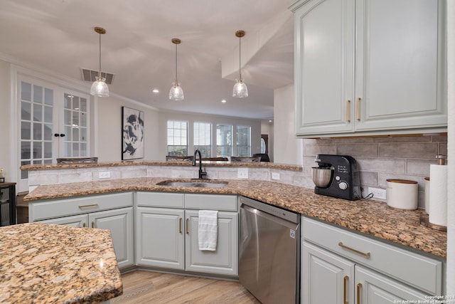 kitchen featuring sink, stainless steel dishwasher, light stone countertops, light wood-type flooring, and kitchen peninsula