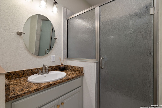 bathroom with vanity and a shower with door