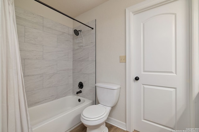 bathroom with toilet, hardwood / wood-style flooring, and shower / tub combo with curtain