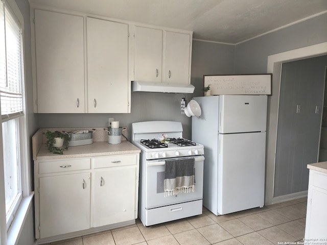 kitchen featuring white cabinets, plenty of natural light, and white appliances