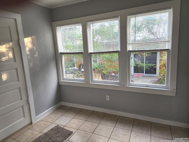 spare room with plenty of natural light and light tile patterned floors