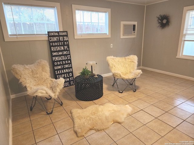 living area with light tile patterned floors and a wall mounted AC