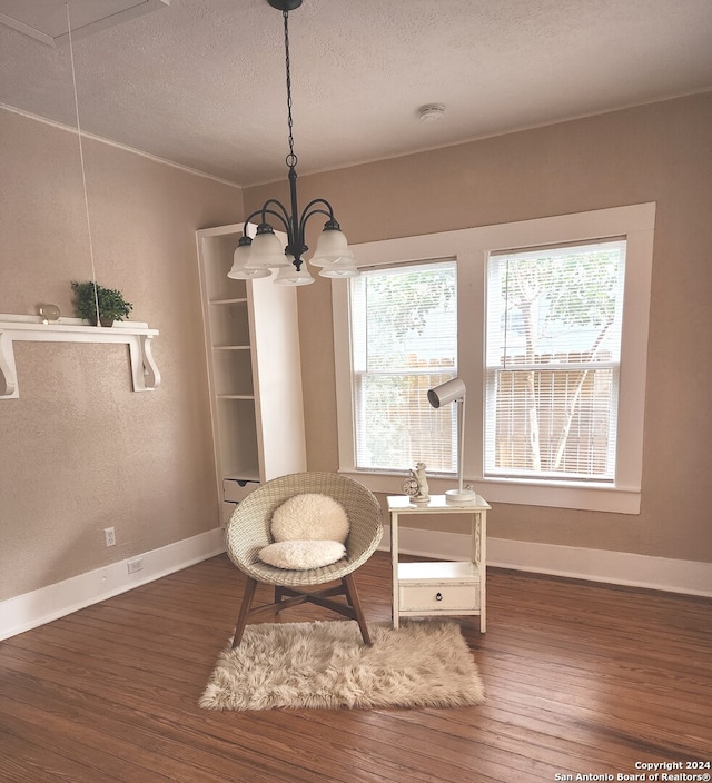 sitting room with a textured ceiling, dark hardwood / wood-style floors, and an inviting chandelier