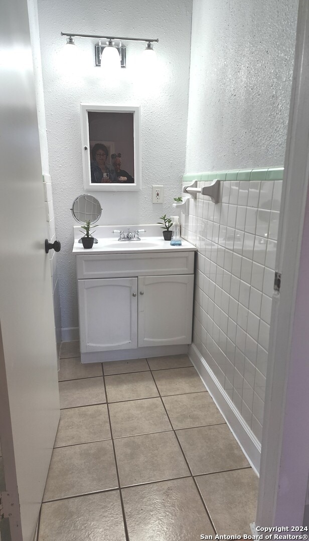 bathroom featuring tile patterned floors, vanity, and tile walls