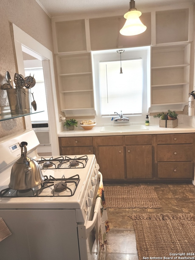 kitchen with decorative light fixtures, gas range gas stove, and sink