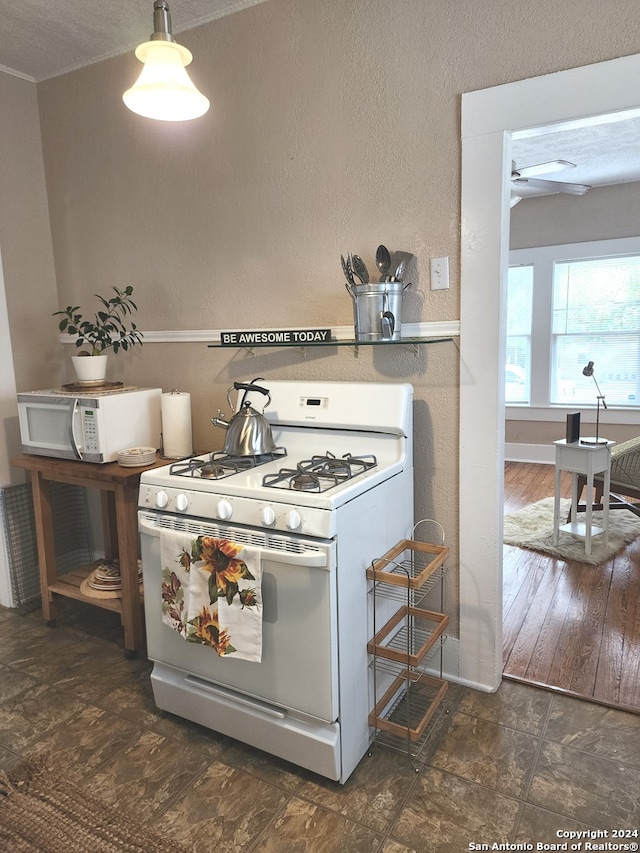 kitchen with a textured ceiling, white appliances, and dark wood-type flooring