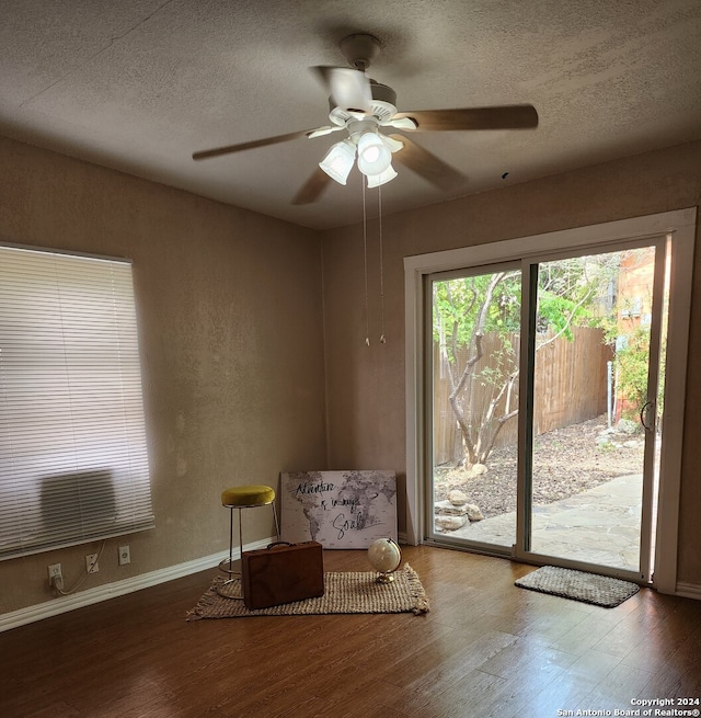 interior space with ceiling fan, a textured ceiling, and hardwood / wood-style flooring