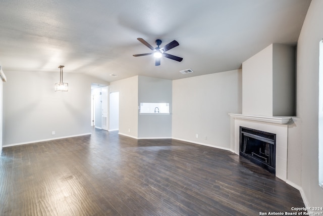 unfurnished living room featuring a fireplace, dark hardwood / wood-style floors, and ceiling fan