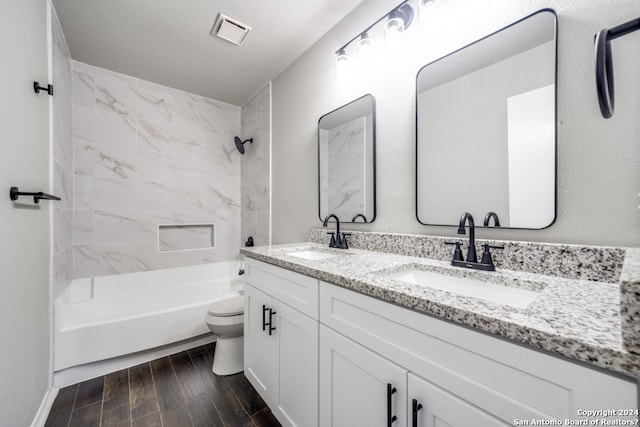 full bathroom with vanity, toilet, wood-type flooring, and tiled shower / bath