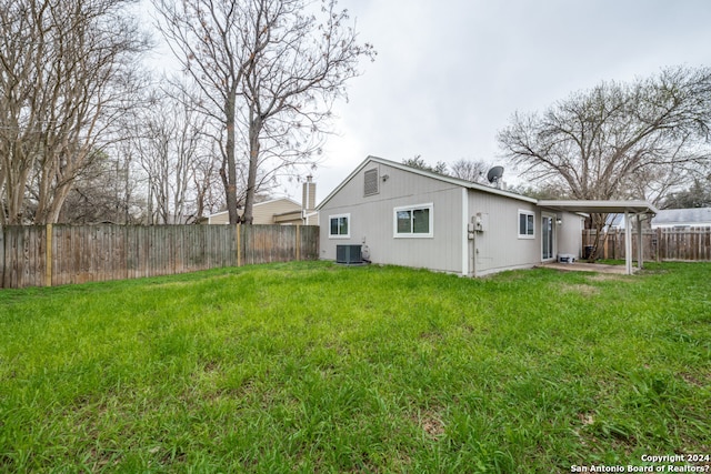 rear view of house featuring a lawn and central air condition unit