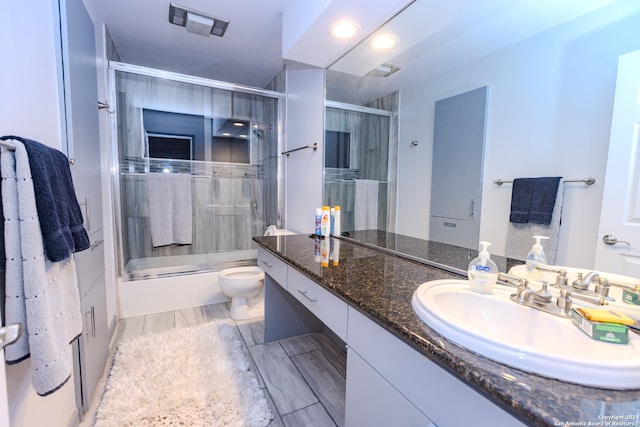 full bathroom with vanity, toilet, and shower / bath combination with glass door