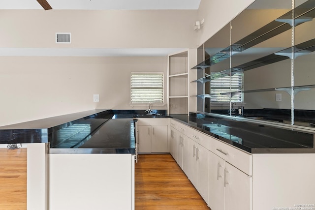 206 Bluff Holw, San Antonio, TX 78216 - kitchen with dark countertops, open shelves, light wood-type flooring, and white cabinetry