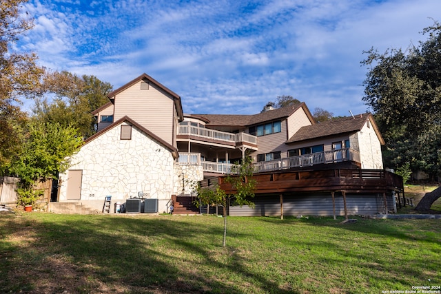 rear view of house with a lawn, a balcony, and central AC