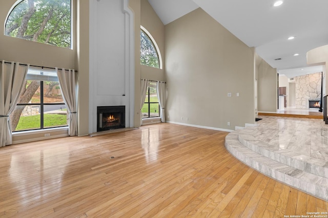 206 Bluff Holw, San Antonio, TX 78216 - unfurnished living room with a large fireplace, high vaulted ceiling, wood-type flooring, recessed lighting, and baseboards