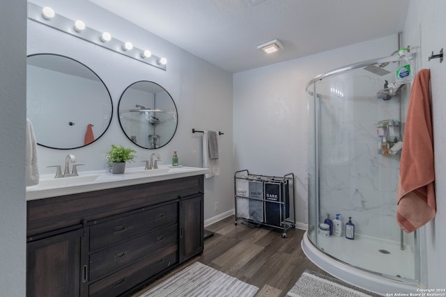 bathroom featuring hardwood / wood-style floors, vanity, and a shower with shower door