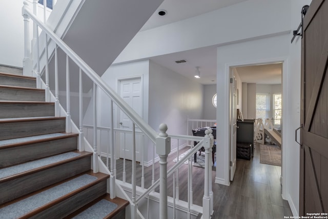 staircase featuring a barn door and hardwood / wood-style floors