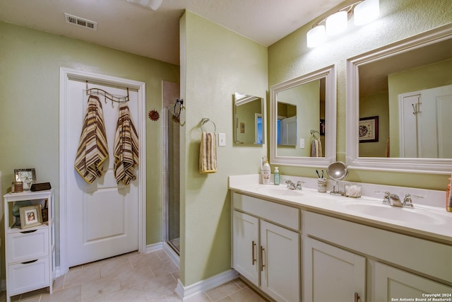 bathroom with tile patterned floors, vanity, and walk in shower