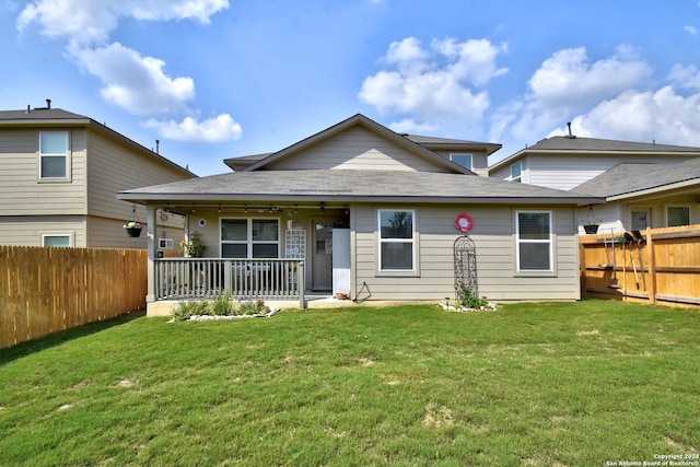 rear view of house featuring a lawn and ceiling fan