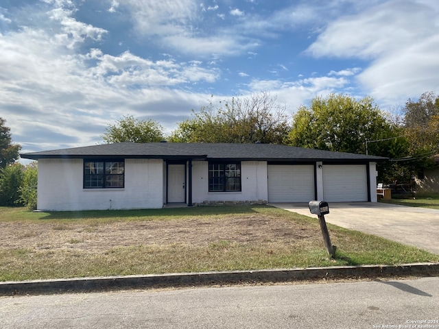 ranch-style home with a garage and a front lawn