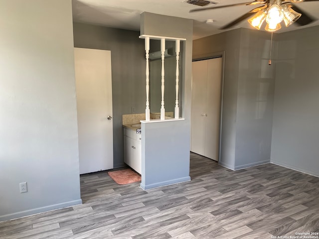 empty room with ceiling fan and light hardwood / wood-style flooring