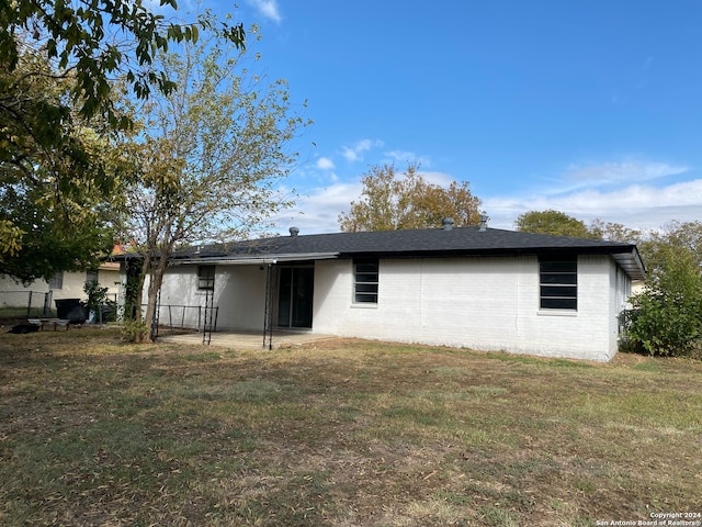 back of house featuring a lawn