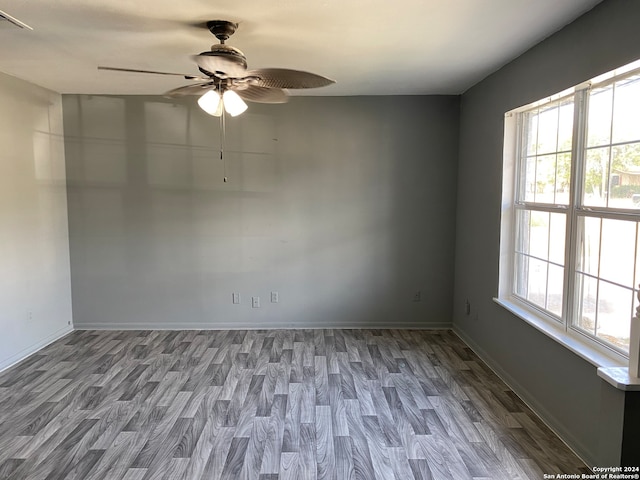 unfurnished room featuring hardwood / wood-style flooring, ceiling fan, and a wealth of natural light