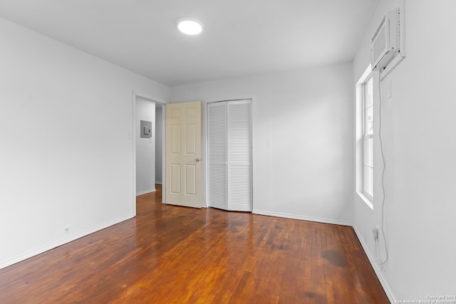 unfurnished bedroom with dark hardwood / wood-style flooring and electric panel