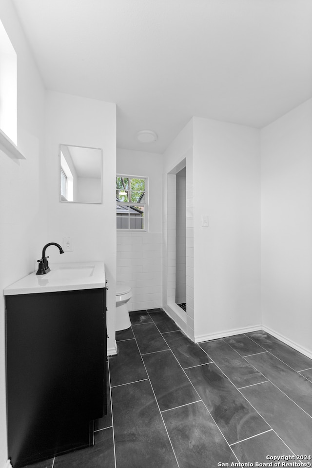 bathroom featuring tile patterned floors, a shower, vanity, and toilet