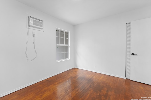 spare room with a wall unit AC and hardwood / wood-style flooring