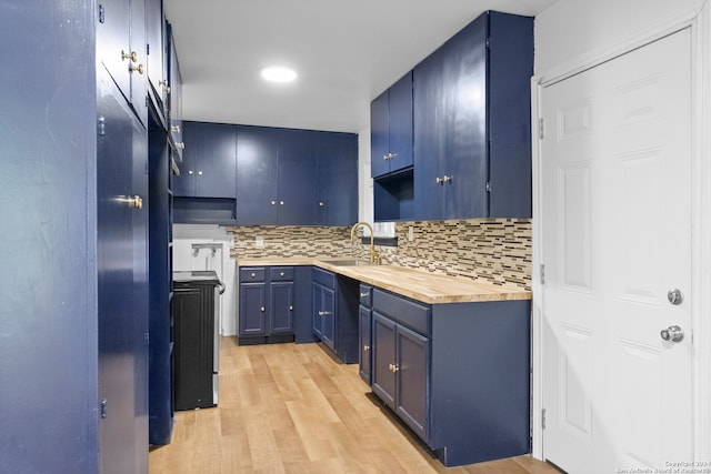 kitchen with stove, backsplash, sink, blue cabinetry, and light hardwood / wood-style floors